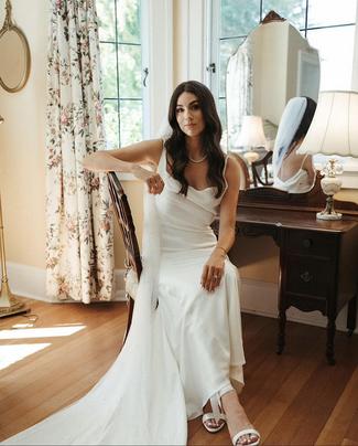 Bride posing for a portrait next to a vanity